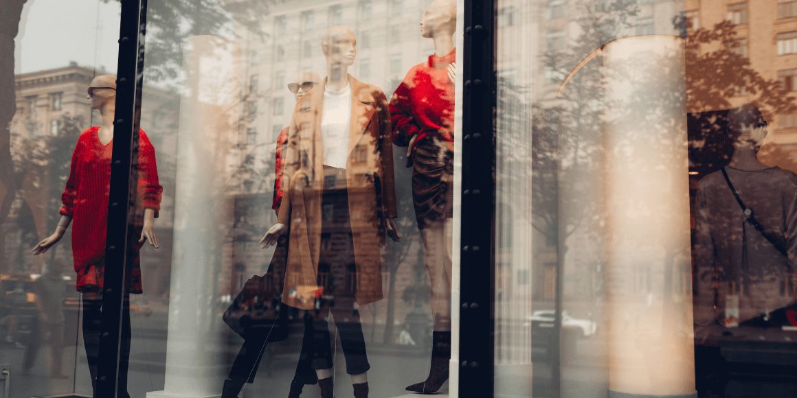 city storefront window with mannequins in fall attire